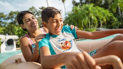 A mother and son riding an inner tube in the pool at the end of the Crush n Gusher waterslide at Disney’s Typhoon Lagoon water park