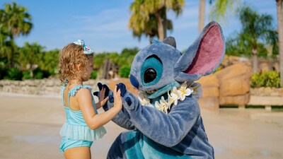 Stitch holding hands with a young girl on the beach
