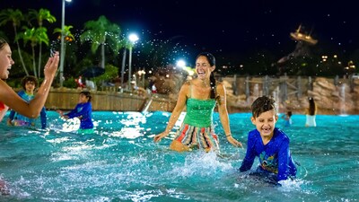 Two young Guests with their mother playing in the waters of Typhoon Lagoon Surf Pool during Disney H2O Glow After Hours