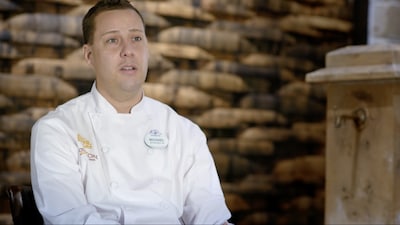 Chef Michael Gonsalves in his white chef's coat, wearing a ‘Michael’ name badge
