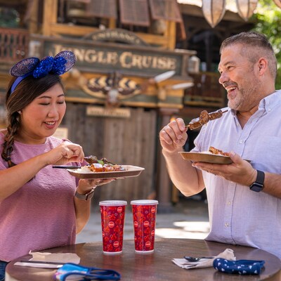 A female and Male guest enjoy small bites outside of Jungle Cruise