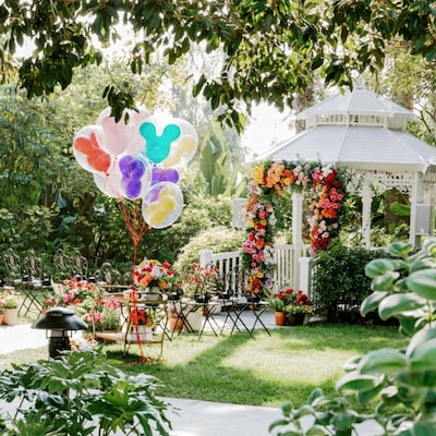 Un lugar para celebrar bodas con jardín, glorieta, arco floral, arreglos florales, sillas y globos de Mickey Mouse