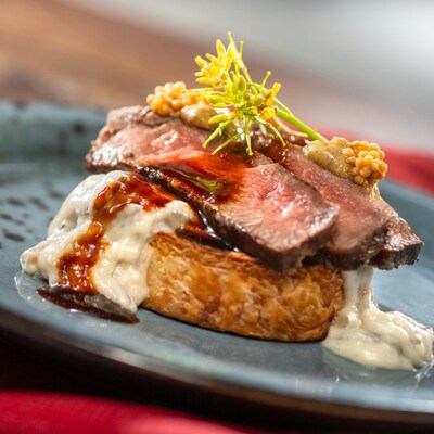 Beef Wellington inspired Croissant Supreme with creamed spinach pinwheel, mushroom gorgonzola ragout, mustard grilled flank steak, red wine sauce and pickled mustard seeds