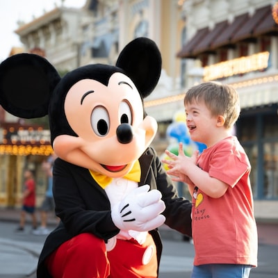 Mickey Mouse greeting a young, smiling boy