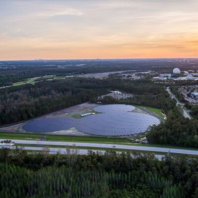 Painéis solares dispostos no formato do Mickey Mouse perto de vários edifícios grandes e da atração Spaceship Earth