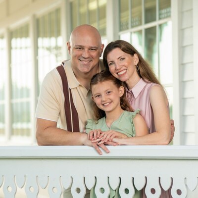 A family of 3 posing for a photo during a portrait session at Walt Disney World Resort