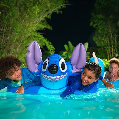 Two young Guests playing with a Stitch pool float during Disney H2O Glow After Hours at Disney’s Typhoon Lagoon