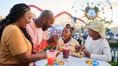 A family of 4 enjoying a meal near the Pixar Pal A Round attraction in Disney California Adventure Park