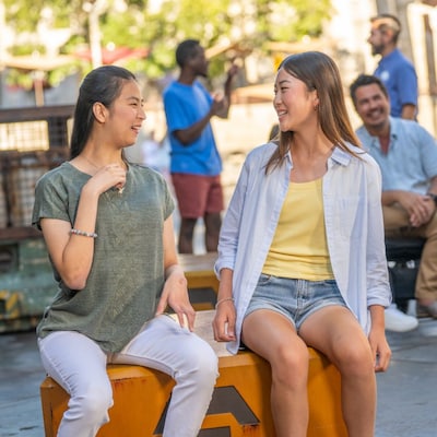 Dos niñas sentadas juntas y riéndose en Star Wars: Galaxy’s Edge en Disneyland Park.