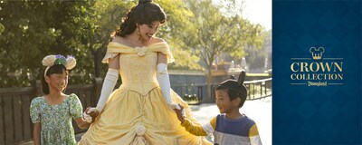 Two smiling children wearing Ear Headbands and holding hands with Belle, with text that says, ‘Crown Collection Disneyland Resort’
