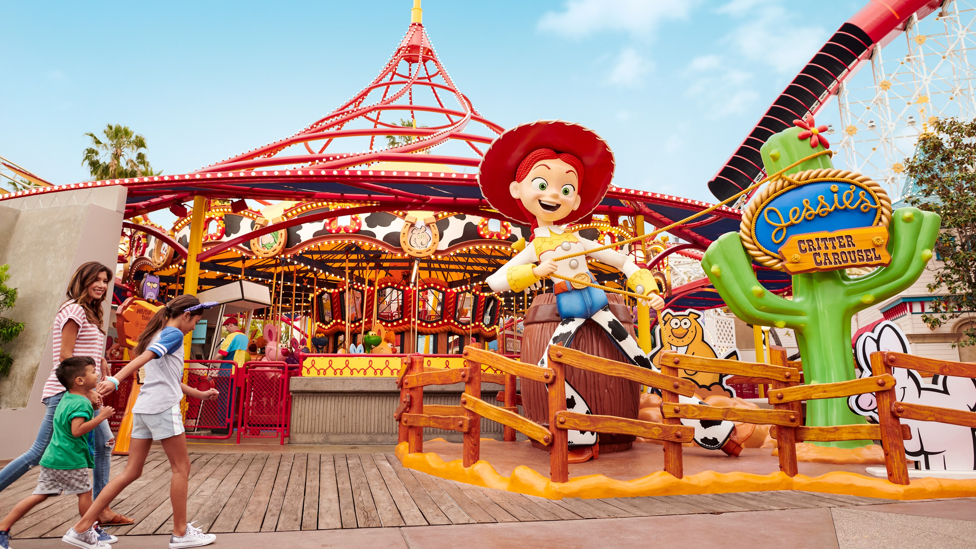 Una mamá y sus hijos se acercan a Jessie’s Critter Carousel