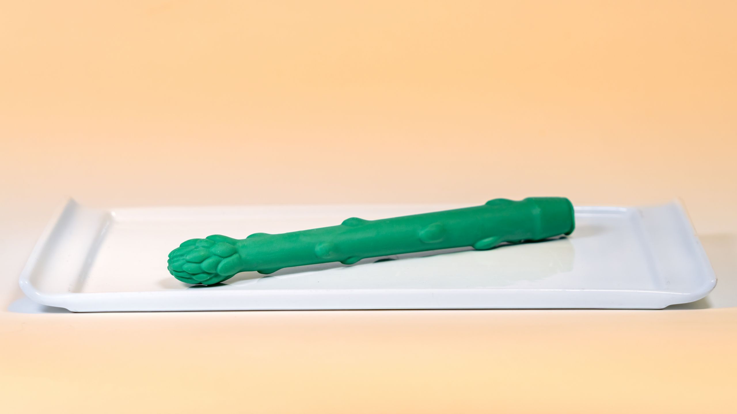 An oversized asparagus shaped novelty food item on a white tray, available during Bluey's Best Day Ever