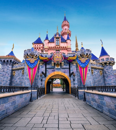 Sleeping Beauty Castle at the Disneyland Resort, decorated with banners and a large 70 medallion for the seventieth anniversary