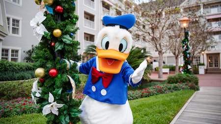 Donald Duck posant à côté d’un lampadaire avec une guirlande des Fêtes au Disney’s Yacht Club Resort