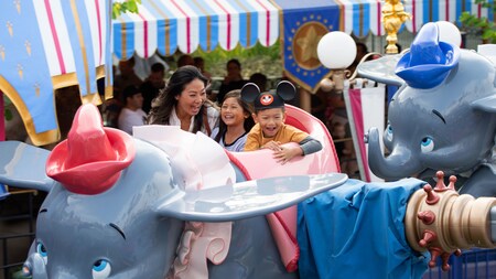 A mom and daughter riding Dumbo the Flying Elephant at Disneyland Park