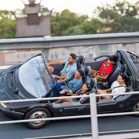 A family of 5 Guests smiling as they ride Test Track at Epcot