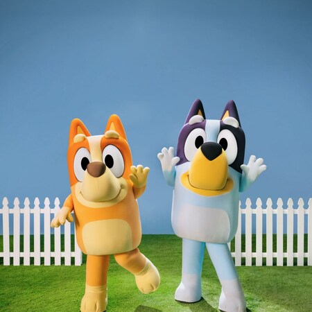 Bingo and Bluey standing together while waving