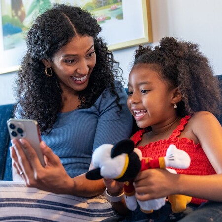 A mom holding her phone up for her daughter