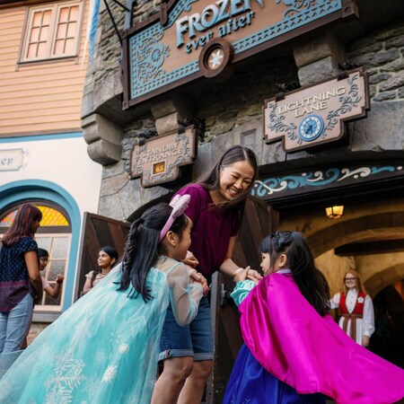 Two girls running to their mother in front of Frozen Ever After in Epcot