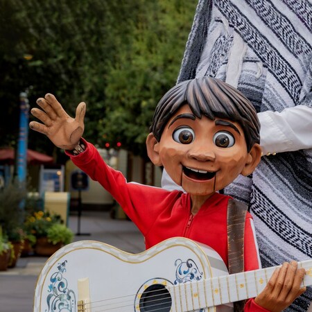 A life size puppet of Miguel from ‘Coco’ holding a guitar and waving