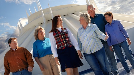 A tour group and guide stroll in front of Space Mountain at Disneyland Park