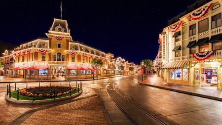Una mar de estrellas llena el cielo mientras brillantes luces iluminan Main Street U.S.A. en Disneyland Park
