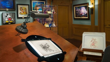 Un dibujo de Mickey Mouse del cortometraje animado Steamboat Willie exhibido en un caballete de artista dentro de Disneyana