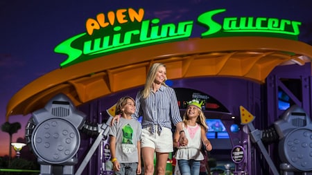 A woman and 2 kids stand in front of Alien Swirling Saucers