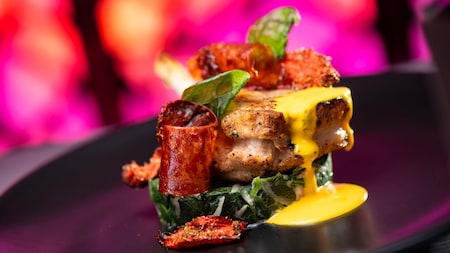 A Smoked Pork Chop on a plate with sauce from Toledo Tapas, Steak & Seafood