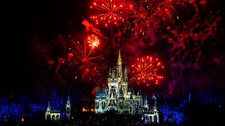 Fireworks bursting above Cinderella Castle at night