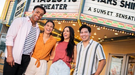 Four friends laugh while standing in front of a marquee on Sunset Boulevard at Disney’s Hollywood Studios