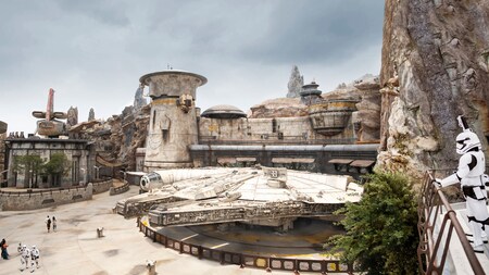 El Millennium Falcon atracado en Star Wars, Galaxy’s Edge con un stormtrooper parado en un balcón cercano