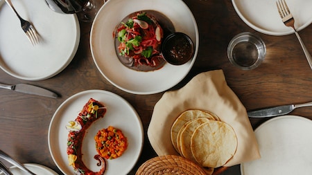 A table set with several Mexican dishes and beverages