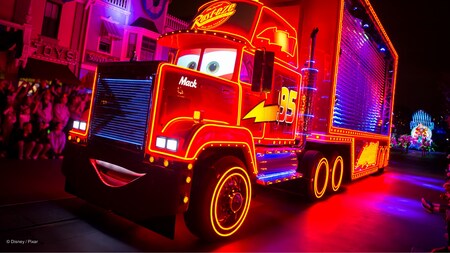 Mack illuminated near Main Street, USA at the Paint the Night Parade