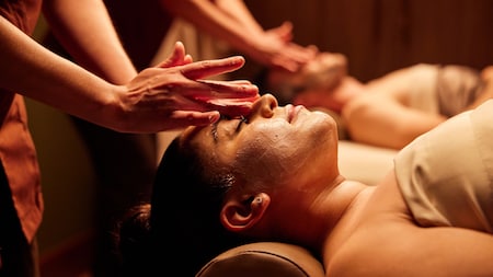 Una pareja disfrutando de un masaje relajante que incluye especial atención al rostro, en Tenaya Stone Spa.