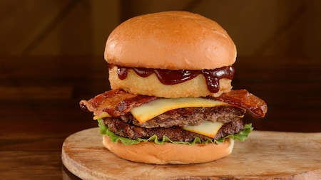 The Barbecue Burger at D-Luxe Burger, featuring a beef patty topped with a fried onion ring, cheese, bacon, barbecue sauce and lettuce, served between 2 buns