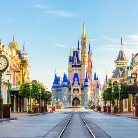 Main Street U S A in Magic Kingdom park at Walt Disney World Resort with storefronts, streetcar tracks and Cinderella Castle