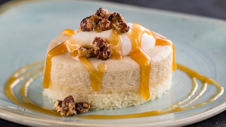 A serving of cheesecake with walnuts and a syrupy topping