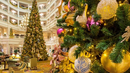 A grand hotel lobby decorated for the holidays complete with Christmas trees and garlands