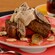 Banana bread on a plate with cream and fresh bananas