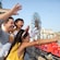 A family waves to passengers riding on a roller coaster at Disney California Adventure park.