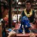 A young girl holding a remote control tests the R series droid she just built as a friend and a technician at Droid Depot look on.