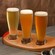 A flight of 3 beers served on a wooden airplane propeller
