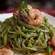 A plate of spinach linguine with shrimp