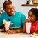 A father and 2 children enjoy lunch and milkshakes at 50's Prime Time Café