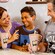 A mother and father flank their son at a table with 2 milkshakes