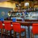 A wood and glass-block bar area with shelves of bottles and vintage TV sets