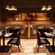 Two tables for 2 parallel to 2 large banquette booths against a brick wall