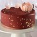 An Amorette’s Patisserie signature cake on a pedestal next to its hat box packaging