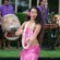 A smiling hula dancer extending her arms during a performance at Disney Springs
